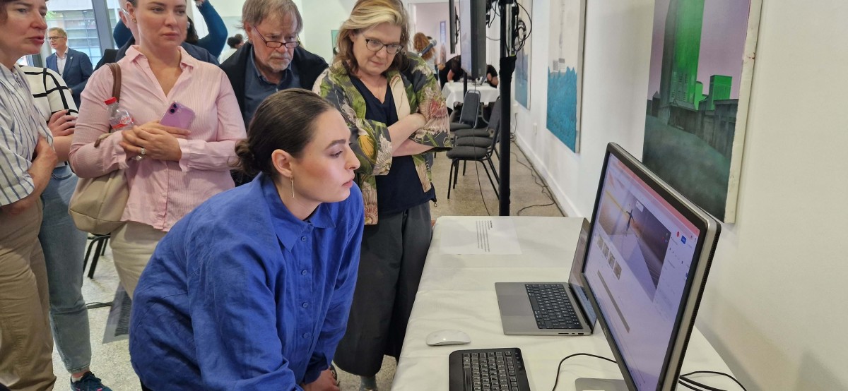 Four women and one man surround a screen looking at a motion capture figure